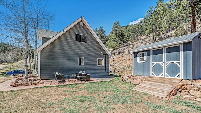 back of property with a storage unit, a lawn, and a patio