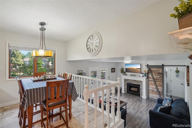 dining space featuring a fireplace, hardwood / wood-style floors, a textured ceiling, and a wealth of natural light