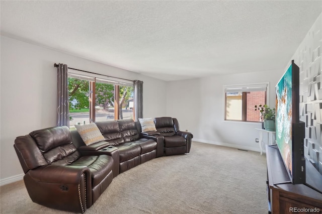 living room featuring carpet flooring, a healthy amount of sunlight, and a textured ceiling