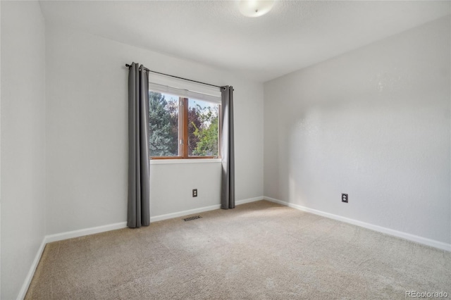 spare room featuring light colored carpet