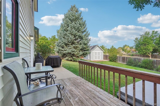 wooden deck featuring a lawn and a storage shed