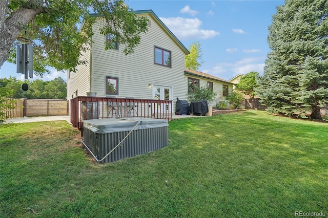 rear view of house featuring a deck and a yard