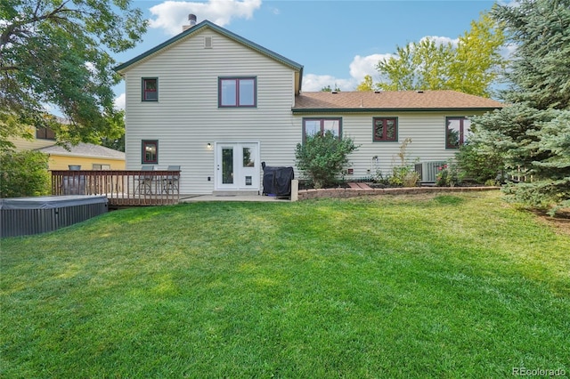 rear view of house featuring a patio, a yard, a deck, and cooling unit