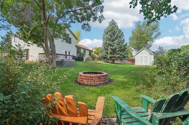 view of yard with a fire pit, a storage unit, and a deck