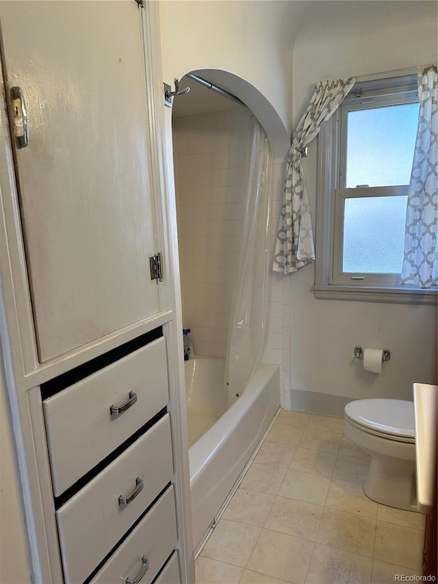 full bath with shower / tub combo with curtain, toilet, and baseboards
