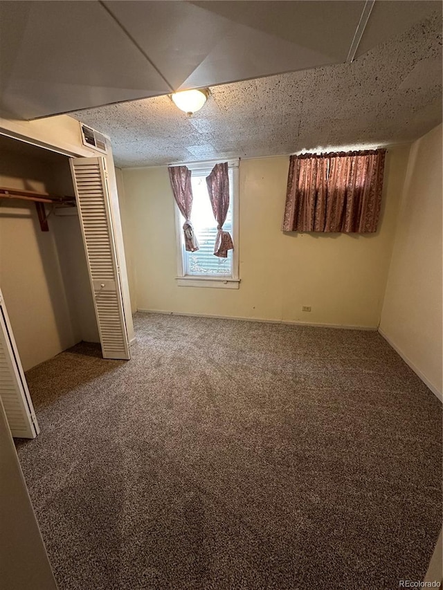 unfurnished bedroom with carpet floors, a closet, and visible vents