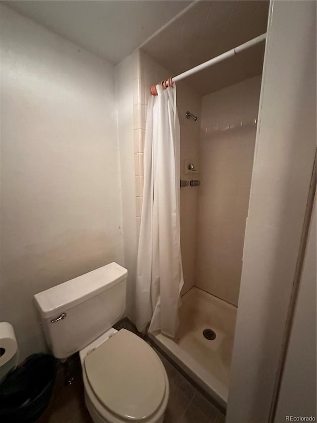 bathroom with toilet and a stall shower