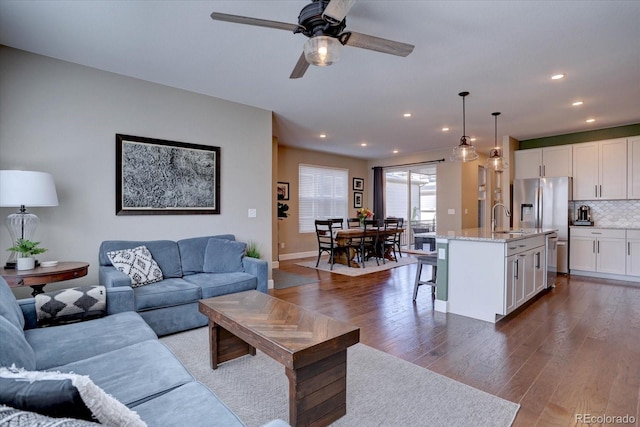 living area featuring ceiling fan, baseboards, dark wood finished floors, and recessed lighting