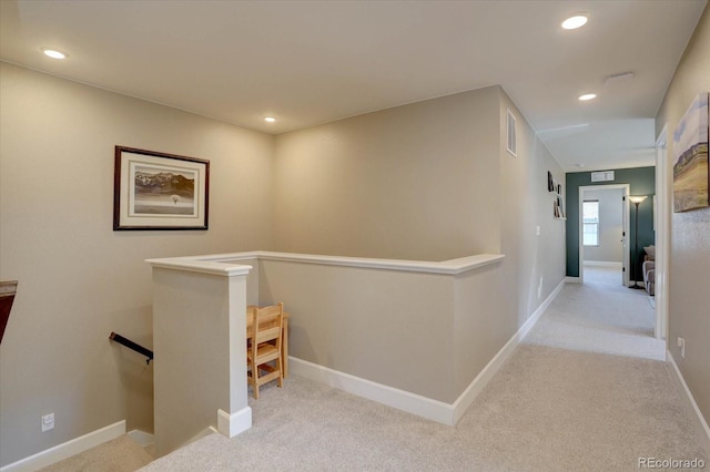 hall featuring light colored carpet, recessed lighting, baseboards, and an upstairs landing