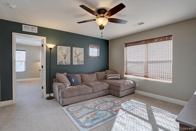 living room featuring light colored carpet, visible vents, and baseboards