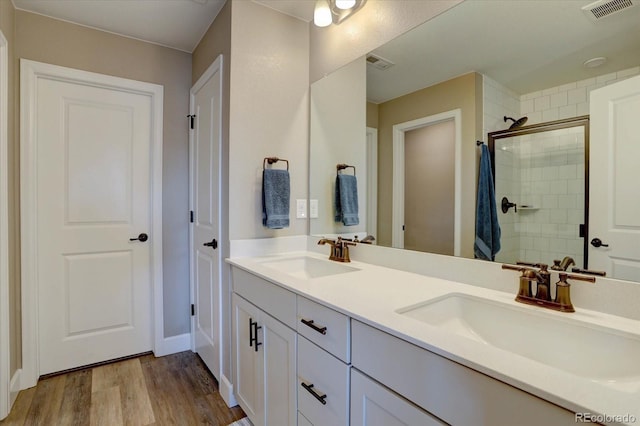 full bath featuring a stall shower, a sink, and visible vents