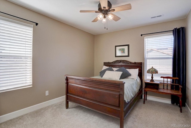 bedroom with light carpet, baseboards, visible vents, and ceiling fan