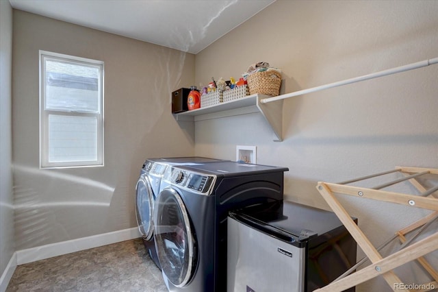 washroom featuring laundry area, washer and clothes dryer, and baseboards