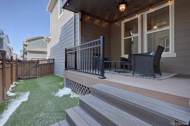 wooden deck featuring a gate, fence, and ceiling fan