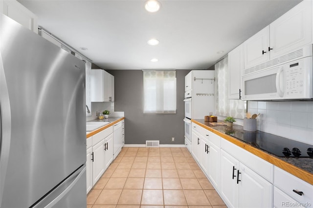 5740 S Cherokee St, Littleton, CO 80120 - kitchen featuring white appliances, tasteful backsplash, white cabinets, recessed lighting, and light tile patterned floors