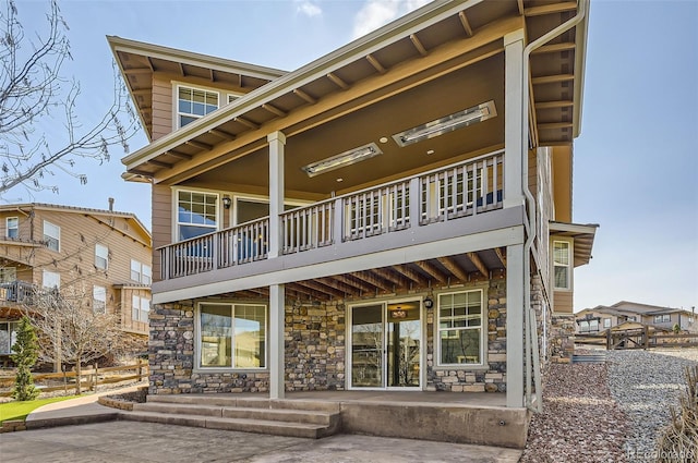 15705 Red Deer Dr, Morrison, CO 80465 - back of property featuring a porch, stone siding, and a balcony