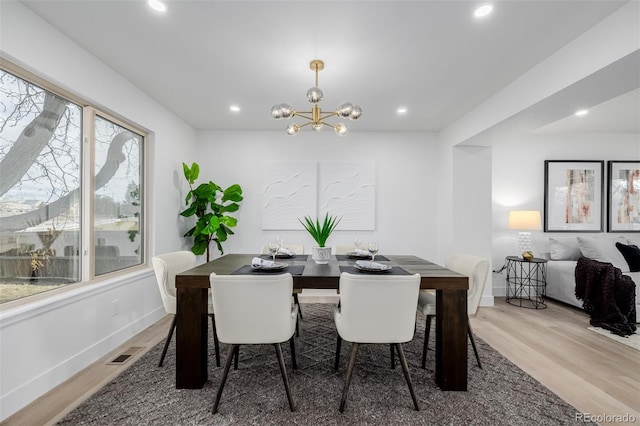 dining room with wood-type flooring and a chandelier