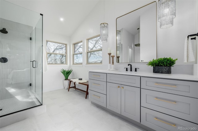 bathroom with vanity, a shower with shower door, and vaulted ceiling