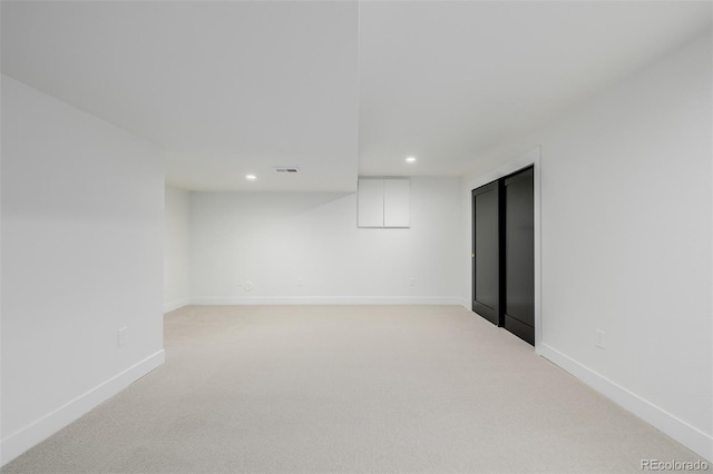 unfurnished room featuring light carpet