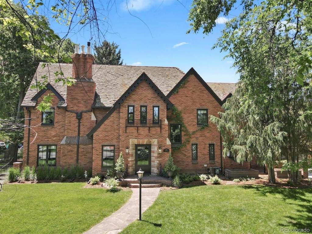 6330 Montview Blvd, Denver, CO 80207 - tudor house featuring brick siding, a chimney, and a front lawn