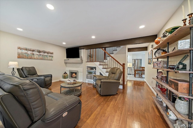 6936 S Knolls Way, Centennial, CO 80122 - living room featuring stairs, a warm lit fireplace, wood finished floors, recessed lighting, and baseboards