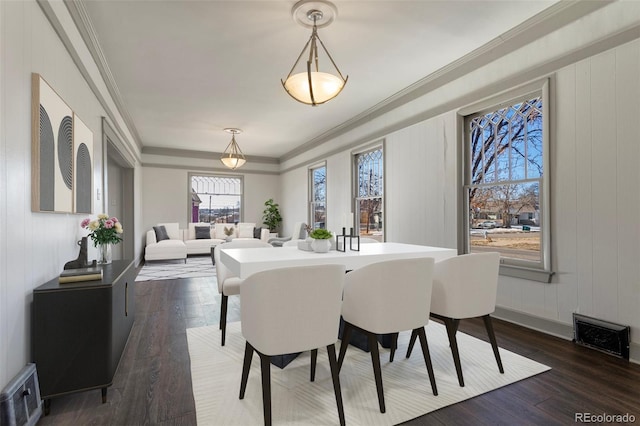 dining area with dark wood-type flooring and crown molding