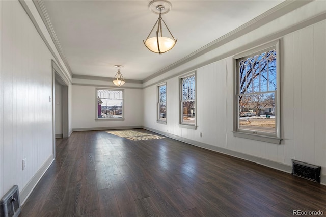 empty room featuring dark wood-type flooring and ornamental molding