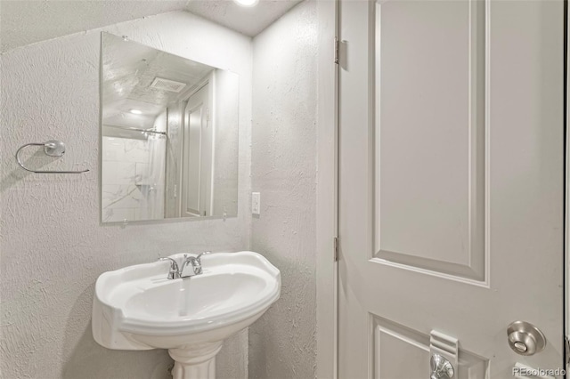 bathroom with a shower with shower curtain and sink