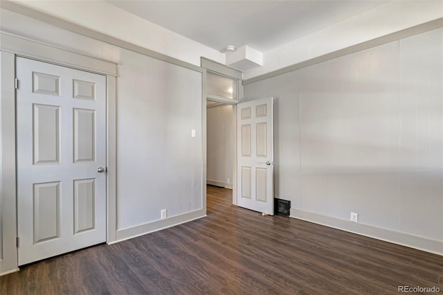 unfurnished bedroom featuring dark wood-type flooring and a closet