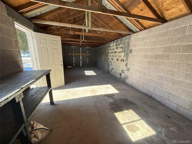 interior space with vaulted ceiling and concrete floors