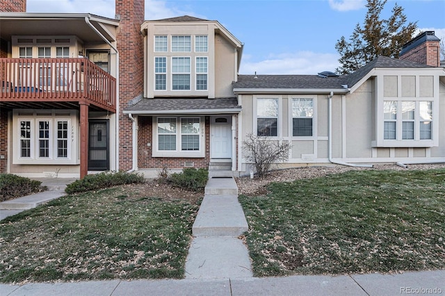 townhome / multi-family property featuring a front lawn