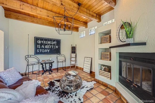 living room with wood ceiling, tile patterned flooring, beam ceiling, a glass covered fireplace, and an inviting chandelier