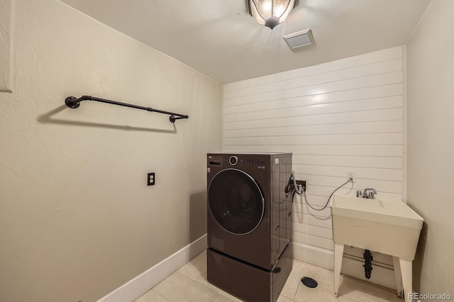 laundry area featuring laundry area, washer / clothes dryer, visible vents, baseboards, and light tile patterned flooring
