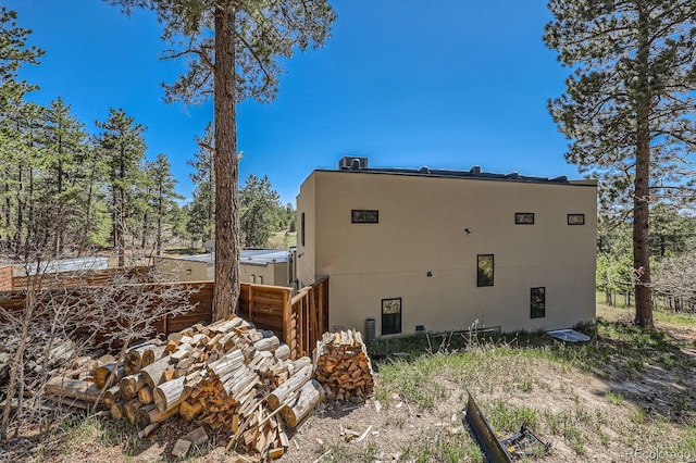 view of property exterior with stucco siding and fence