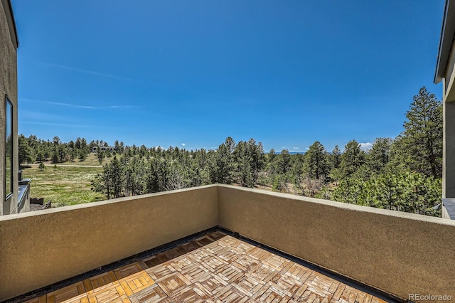 balcony featuring a forest view