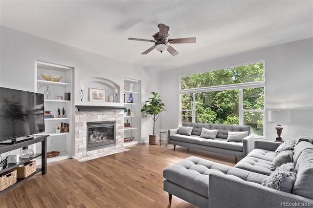 10345 Lions Heart, Lone Tree, CO 80124 - living area with ceiling fan, a fireplace, wood finished floors, and built in shelves
