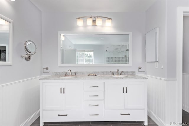 10345 Lions Heart, Lone Tree, CO 80124 - full bath featuring wainscoting, double vanity, and a tile shower