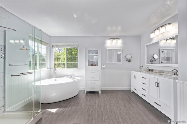 10345 Lions Heart, Lone Tree, CO 80124 - bathroom with a wainscoted wall, wood finished floors, double vanity, a freestanding bath, and a stall shower