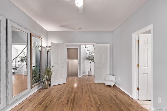 10345 Lions Heart, Lone Tree, CO 80124 - spare room with stairway, wood finished floors, and a ceiling fan
