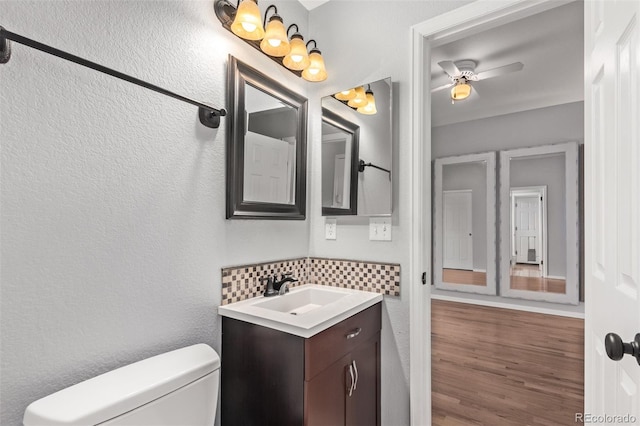 10345 Lions Heart, Lone Tree, CO 80124 - half bath featuring tasteful backsplash, vanity, a ceiling fan, and wood finished floors