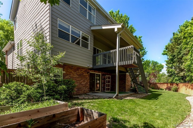 10345 Lions Heart, Lone Tree, CO 80124 - rear view of house with a vegetable garden, stairway, brick siding, a fenced backyard, and a deck