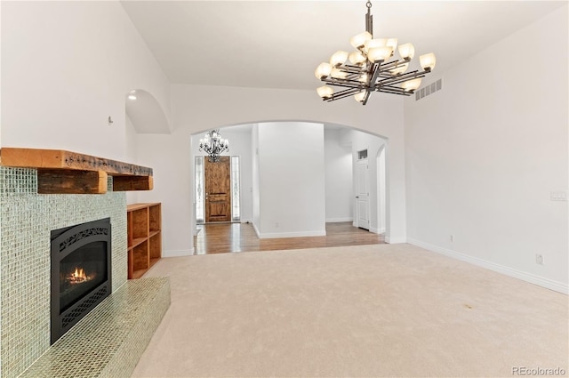 unfurnished living room with carpet floors and an inviting chandelier