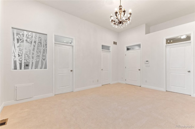 spare room featuring an inviting chandelier and carpet