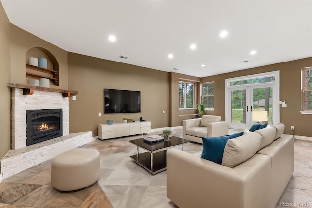 tiled living room featuring a fireplace and french doors