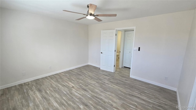 unfurnished bedroom featuring a ceiling fan, baseboards, and wood finished floors