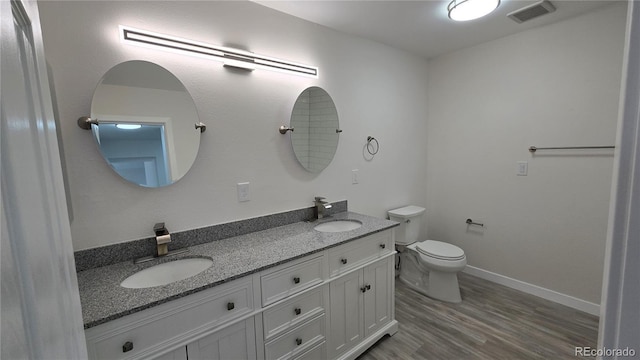 full bath featuring toilet, wood finished floors, visible vents, and a sink