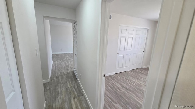 hall with dark wood-style floors and baseboards