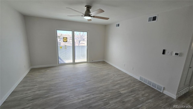 empty room with visible vents, baseboards, and wood finished floors