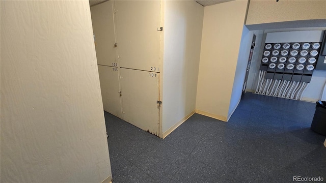 hallway with tile patterned floors and baseboards