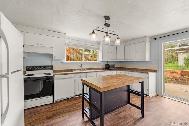 720 N Walnut St, Colorado Springs, CO 80905 - kitchen featuring white appliances, under cabinet range hood, dark wood-style floors, white cabinetry, and decorative light fixtures